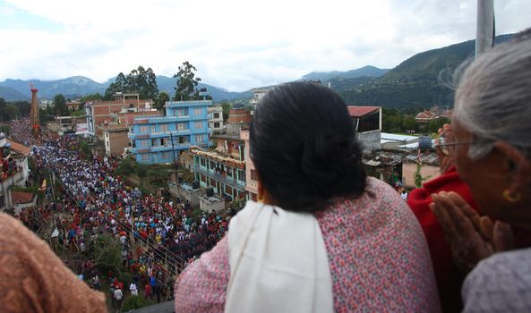 NEPAL, Patan: Nepalese women look on during the festival of rain god Rato Machindranath in Patan, Nepal on September 22, 2015. The festival takes place each April, but was delayed this year after a devastating earthquake damaged the chariot that devotees pull through the area in the hope of securing a good harvest.
