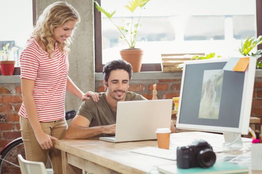 Business people working on laptop in creative office