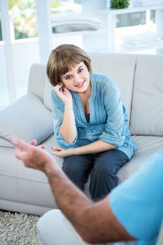 Portrait of smiling beautiful woman sitting in front of father at home