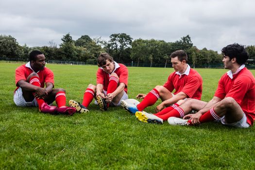 Rugby players sitting on grass before match at the park