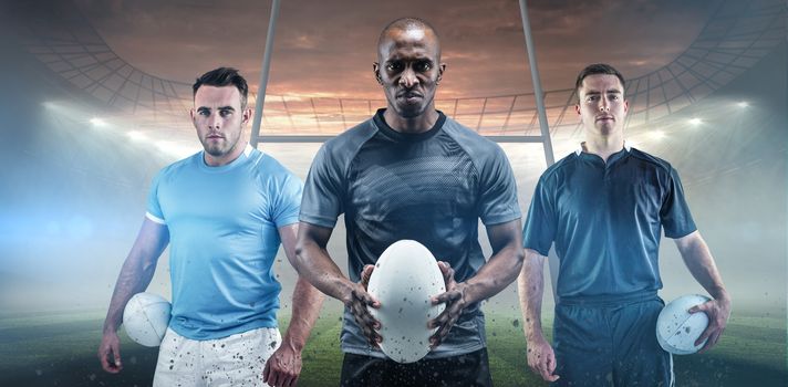 Rugby player holding a rugby ball against rugby stadium