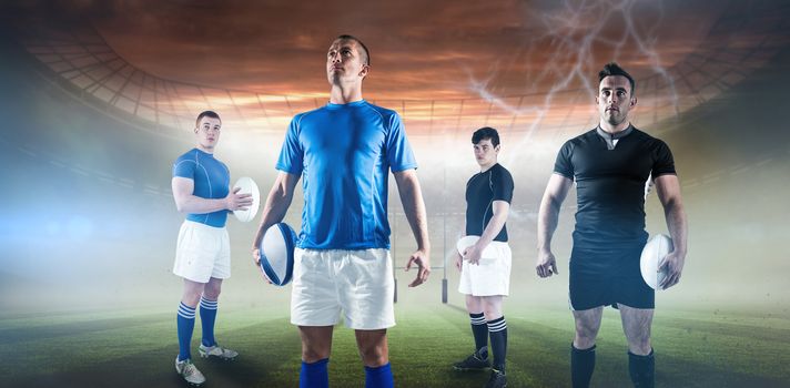 Rugby player holding rugby ball against rugby pitch