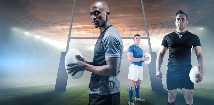 Rugby player holding rugby ball against rugby stadium