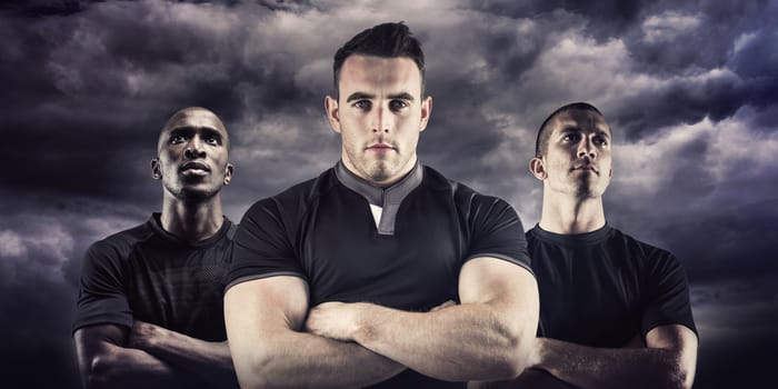 Tough rugby player looking at camera against cloudy sky