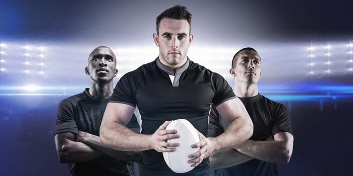 Tough rugby player looking at camera against spotlights