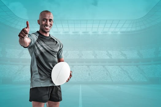 Portrait of confident rugby player smiling and showing thumbs up against blue vignette background