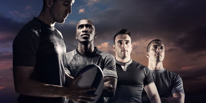 Calm rugby player thinking while holding ball against blue and orange sky with clouds