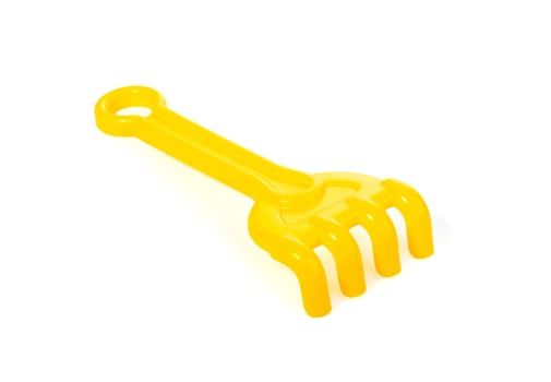 yellow plastic children's toy rake for the sandbox isolated on white background