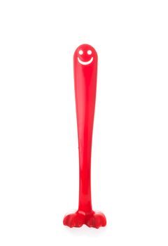 Red plastic shoehorn or shoespoon with a smiling face like a big long penis isolated on white background, the concept of an erection, potency, sexual health