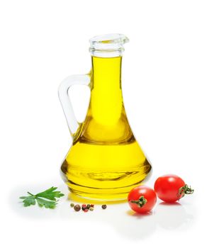 Olive oil in a glass jug, cherry tomatoes, a mixture of peppers, on a white background. Spices, herbs, vegetable oil.