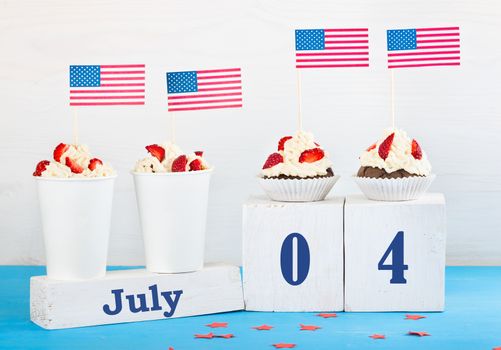 greeting card on the Independence Day of America, two cupcakes, two desserts with cream, strawberries, perpetual calendar with the words Jule 4 on a white and blue background