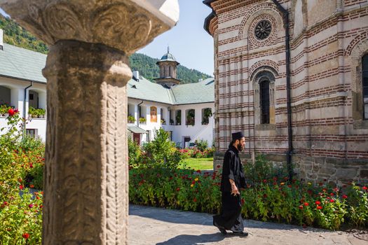 Cozia, Romania - Septemper 2, 2012: Priest walking inside Cozia monastery church housing the tomb of Mircea the Elder, Romania