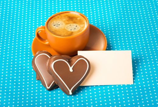 ceramic cup with coffee  espresso, tablet for text and two chocolate marzipan candy hearts on a bright blue background, love concept, have a nice day, good morning, good day, happy Valentine's Day