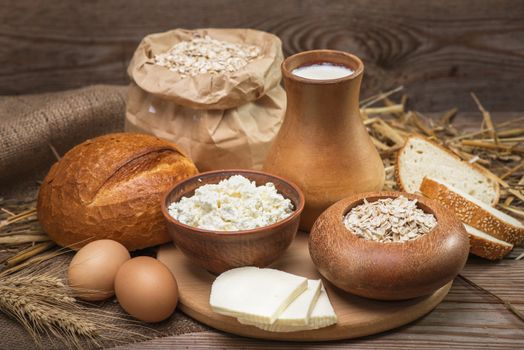 Farmers rustic natural organic foods, balanced diet, cooking, culinary, food concept, dairy products, bread,  oatmeal, cheese, cottage cheese, eggs, milk on the old wooden background
