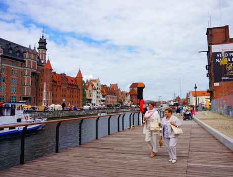 GDANSK, POLAND - JULY 29, 2015: People walling on a path next to the Motlawa river in the city center