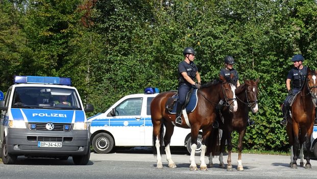 AUSTRIA, Salzburg: Police officials stand guard on horseback as scores line up at the border control in Salzburg, Austria on September 22, 2015 amid an ongoing refugee crisis, which has seen thousands flee from Syria and other war-torn countries for safety in Europe.