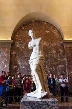 Paris, France - May 13, 2015: Tourists visit The Venus de Milo statue at the Louvre Museum in Paris. The Venus de Milo statue it's one of most important statue of the world.