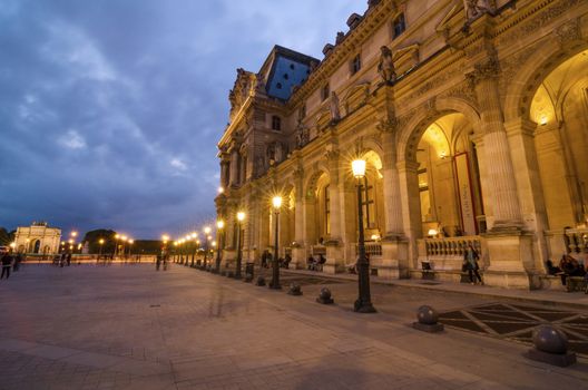 Paris, France - May 14, 2015: Tourists visiting Louvre museum at dusk on May 14, 2015 in Paris. This is one of the most popular tourist destinations in France.