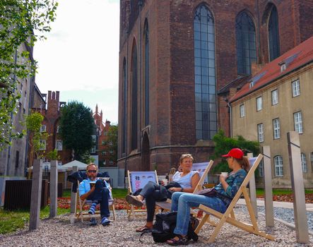 GDANSK, POLAND - JULY 29, 2015: People relaxing on sun chairs at the city center