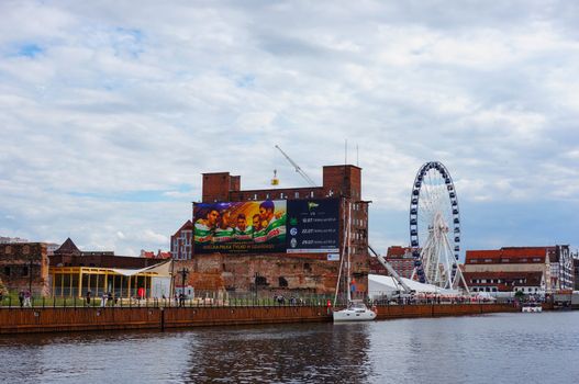 GDANSK, POLAND - JULY 29, 2015: Buildings and fair wheel by the Motlawa river in the city center