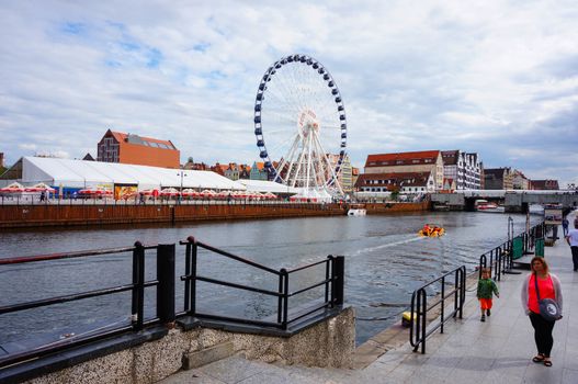 GDANSK, POLAND - JULY 29, 2015: Buildings and fair wheel by the Motlawa river in the city center