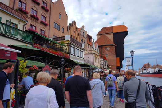 GDANSK, POLAND - JULY 29, 2015: Many people walking on a street next to the Motlawa river in the city center