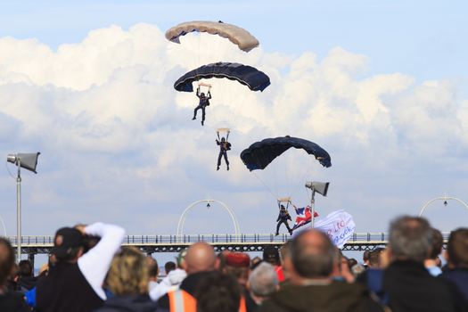 ENGLAND, Southport: Parachuting pilots prepare to land in formation during the Southport Airshow 2015 in Southport, Merseyside in England on September 19, 2015