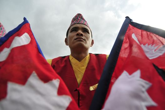 NEPAL, Kathmandu: A man holds two flags at celebrations in Kathmandu, Nepal on September 21, 2015, one day after the government unveiled the country's first democratic constitution in a historic step. Out of the 598 members of the Constituent Assembly, 507 voted for the new constitution, 25 voted against, and 66 abstained in a vote on September 16, 2015. The event was marked with fireworks and festivities, but also with protests organized by parties of the Tharu and Madhesi ethnic communities.Photos taken by Newzulu contributor Narayan Maharjan show the Nepalese people donning traditional garb and celebrating with folk music and dancing.