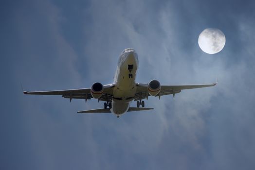 An Aircraft landing with full moon.