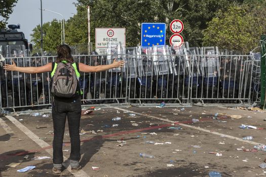 SERBIA, Horgos: A refugee stands defiant at the border after Hungarian police fired tear gas and water cannons into the refugees in the Serbian border town of Horgos on September 16, 2015, after Hungary closed its border in an effort to stem the wave of refugees entering the country. 