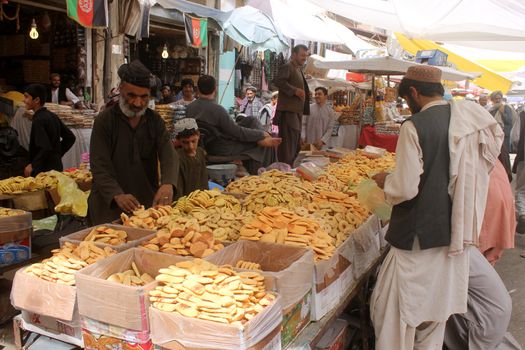 AFGHANISTAN, Kandahar: Crowds are out shopping in Charso Bazaar for Eid on September 22, 2015. Men in traditional dress and women in burqas buy dried fruits, biscuits, clothes, shoes, hats and things for their homes in Charso Bazaar, Kandahar. 