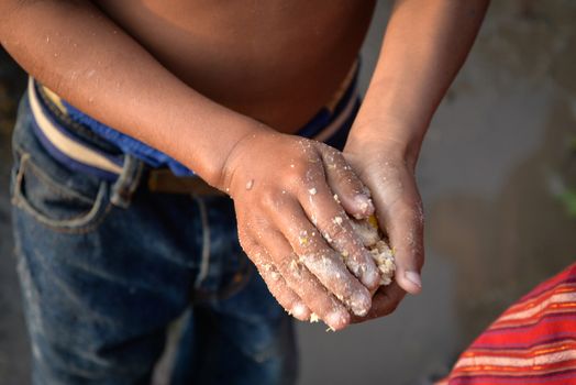 NEPAL, Nuwakot: Santosh Shrestha, a 10 year-old boy from Okharpauwa, Nuwakot District performs a religious ritual at Bagamti River Bank during Father's Day, on September 13, 2015.	Santosh's father passed away when he was six months old, and this was his fifth time performing the religious ritual at Gokarna, along with his grandfather, grandmother and his mother. He lives in poverty on a rubbish dump with his family, and is not able to go to school. 