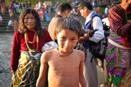 NEPAL, Nuwakot: Santosh Shrestha, a 10 year-old boy from Okharpauwa, Nuwakot District performs a religious ritual at Bagamti River Bank during Father's Day, on September 13, 2015.	Santosh's father passed away when he was six months old, and this was his fifth time performing the religious ritual at Gokarna, along with his grandfather, grandmother and his mother. He lives in poverty on a rubbish dump with his family, and is not able to go to school. 