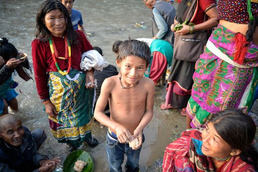 NEPAL, Nuwakot: Santosh Shrestha, a 10 year-old boy from Okharpauwa, Nuwakot District performs a religious ritual at Bagamti River Bank during Father's Day, on September 13, 2015.	Santosh's father passed away when he was six months old, and this was his fifth time performing the religious ritual at Gokarna, along with his grandfather, grandmother and his mother. He lives in poverty on a rubbish dump with his family, and is not able to go to school. 