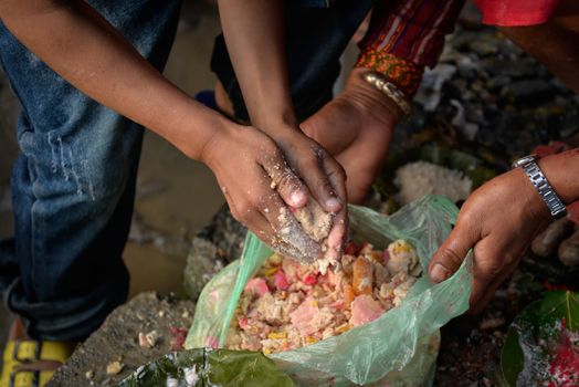 NEPAL, Nuwakot: Santosh Shrestha, a 10 year-old boy from Okharpauwa, Nuwakot District performs a religious ritual at Bagamti River Bank during Father's Day, on September 13, 2015.	Santosh's father passed away when he was six months old, and this was his fifth time performing the religious ritual at Gokarna, along with his grandfather, grandmother and his mother. He lives in poverty on a rubbish dump with his family, and is not able to go to school. 