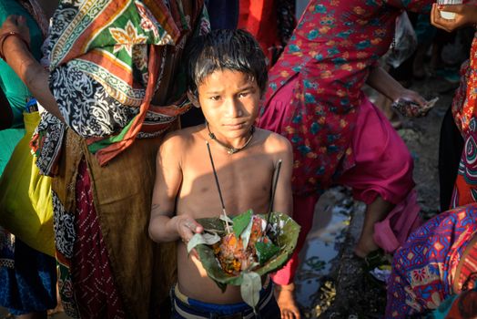 NEPAL, Nuwakot: Santosh Shrestha, a 10 year-old boy from Okharpauwa, Nuwakot District performs a religious ritual at Bagamti River Bank during Father's Day, on September 13, 2015.	Santosh's father passed away when he was six months old, and this was his fifth time performing the religious ritual at Gokarna, along with his grandfather, grandmother and his mother. He lives in poverty on a rubbish dump with his family, and is not able to go to school. 