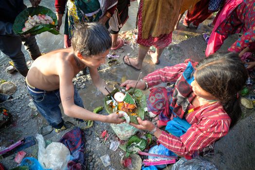 NEPAL, Nuwakot: Santosh Shrestha, a 10 year-old boy from Okharpauwa, Nuwakot District performs a religious ritual at Bagamti River Bank during Father's Day, on September 13, 2015.	Santosh's father passed away when he was six months old, and this was his fifth time performing the religious ritual at Gokarna, along with his grandfather, grandmother and his mother. He lives in poverty on a rubbish dump with his family, and is not able to go to school. 