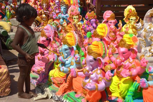 INDIA, Ajmer: An Indian child worker, Shani Bawari (5), puts the finishing touches of colourful paint onto his statues of the Hindu god Lord Ganesh, on September 11, 2015. 	Working on the outskirts of Ajmer, Rajasthan, Shani is preparing the statues for sale ahead of the forthcoming Ganesh Chaturthi festival on 17 September.Arjun Bawari, the boy's father, gave permission for the photos to be taken.