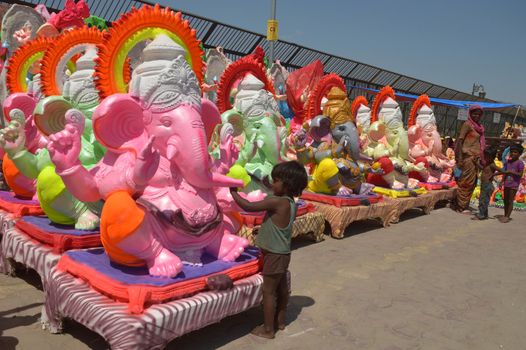 INDIA, Ajmer: An Indian child worker, Shani Bawari (5), puts the finishing touches of colourful paint onto his statues of the Hindu god Lord Ganesh, on September 11, 2015. 	Working on the outskirts of Ajmer, Rajasthan, Shani is preparing the statues for sale ahead of the forthcoming Ganesh Chaturthi festival on 17 September.Arjun Bawari, the boy's father, gave permission for the photos to be taken.