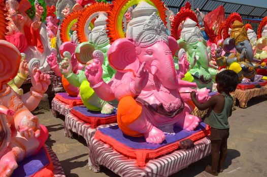 INDIA, Ajmer: An Indian child worker, Shani Bawari (5), puts the finishing touches of colourful paint onto his statues of the Hindu god Lord Ganesh, on September 11, 2015. 	Working on the outskirts of Ajmer, Rajasthan, Shani is preparing the statues for sale ahead of the forthcoming Ganesh Chaturthi festival on 17 September.Arjun Bawari, the boy's father, gave permission for the photos to be taken.