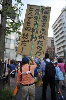 JAPAN, Tokyo : A demonstrator holds a sign against the new legislation that would allow the military to deploy overseas, in Tokyo outside of Japan's parliament against new legislation on September 23, 2015 The changes would allow Japanese troops to fight abroad for the first time since World War Two. 