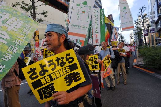 JAPAN, Tokyo : A demonstrator holds a sign against the new legislation that would allow the military to deploy overseas, in Tokyo outside of Japan's parliament against new legislation on September 23, 2015 The changes would allow Japanese troops to fight abroad for the first time since World War Two. 