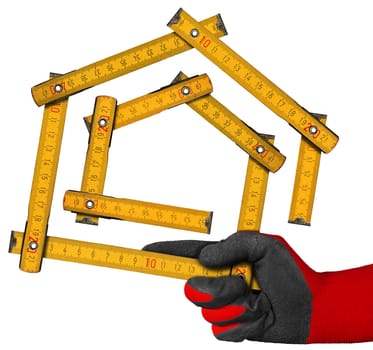 Hand with red and black work glove holding a yellow wooden meter ruler in the shape of house isolated on white background. Concept of house project 
