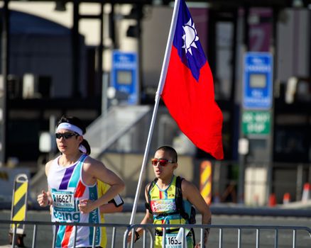 AUSTRALIA, Sydney: A participant runs with the Taiwanese flag during the Sydney Running Festival on September 20, 2015. Around 30,000 participants took part in the 15th Sydney Running Festival which incorporates a 42km marathon, a half marathon, a 9km bridge run as well as a 3.5km family fun run