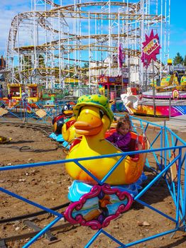 USTRONIE MORSKIE, POLAND - JULY 20, 2015: People on duck train attraction at a fair 