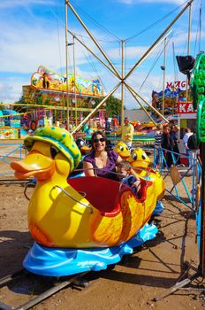 USTRONIE MORSKIE, POLAND - JULY 20, 2015: People on duck train attraction at a fair 