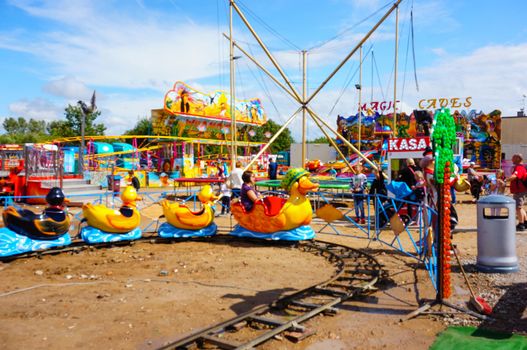 USTRONIE MORSKIE, POLAND - JULY 20, 2015: People on duck train attraction at a fair 