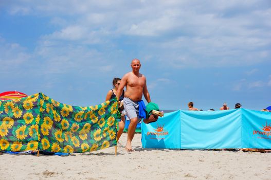 SIANOZETY, POLAND - JULY 22, 2015: People walking on beach sand on a sunny day 