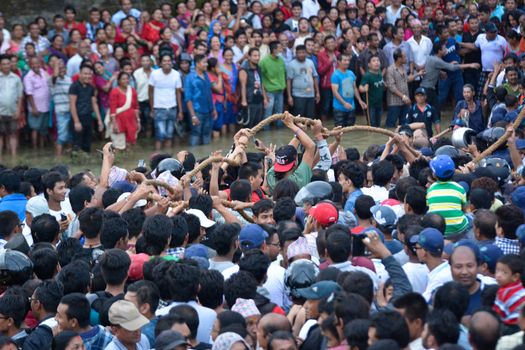 NEPAL, Patan: Hindus and Buddhists gather around the chariot of Rato Machhindranath as it is pulled along a river in Patan, Lalitpur, Nepal, on September 23, 2015. 