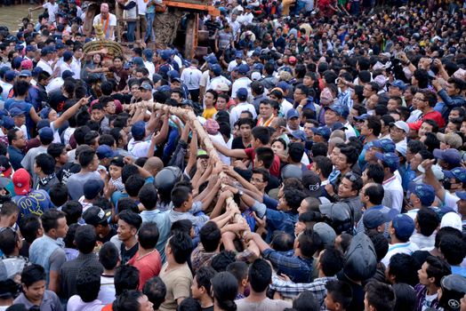 NEPAL, Patan: Hindus and Buddhists gather around the chariot of Rato Machhindranath as it is pulled along a river in Patan, Lalitpur, Nepal, on September 23, 2015. 